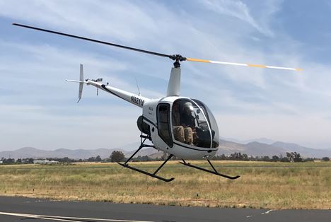 Robinson helicopter in a low training hover over the runway